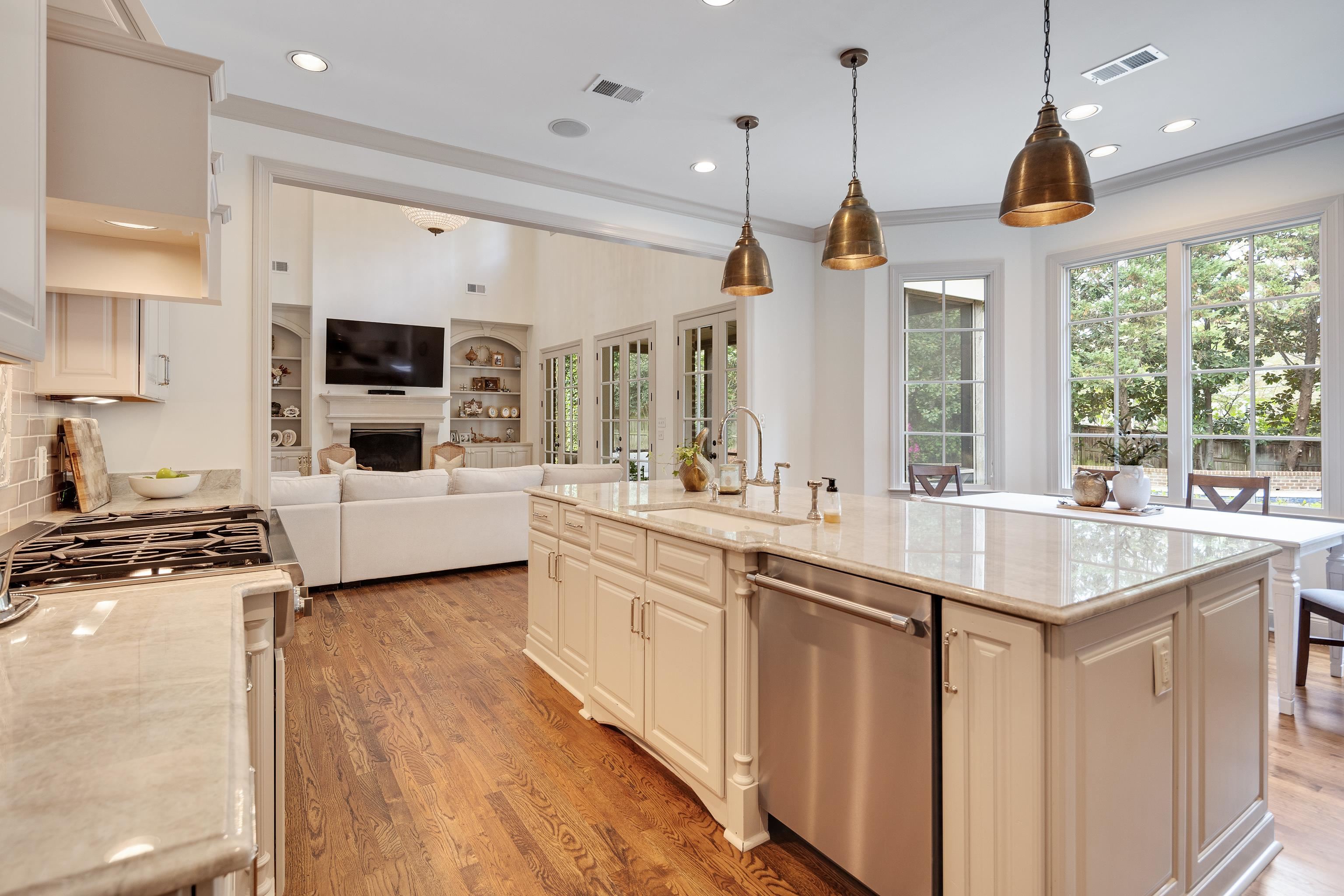 101 North Grove Park Road Memphis, TN 38117 - Photo 39 of 40 Kitchen featuring light stone counters, open floor plan, a fireplace, a center island with sink, and stainless steel appliances