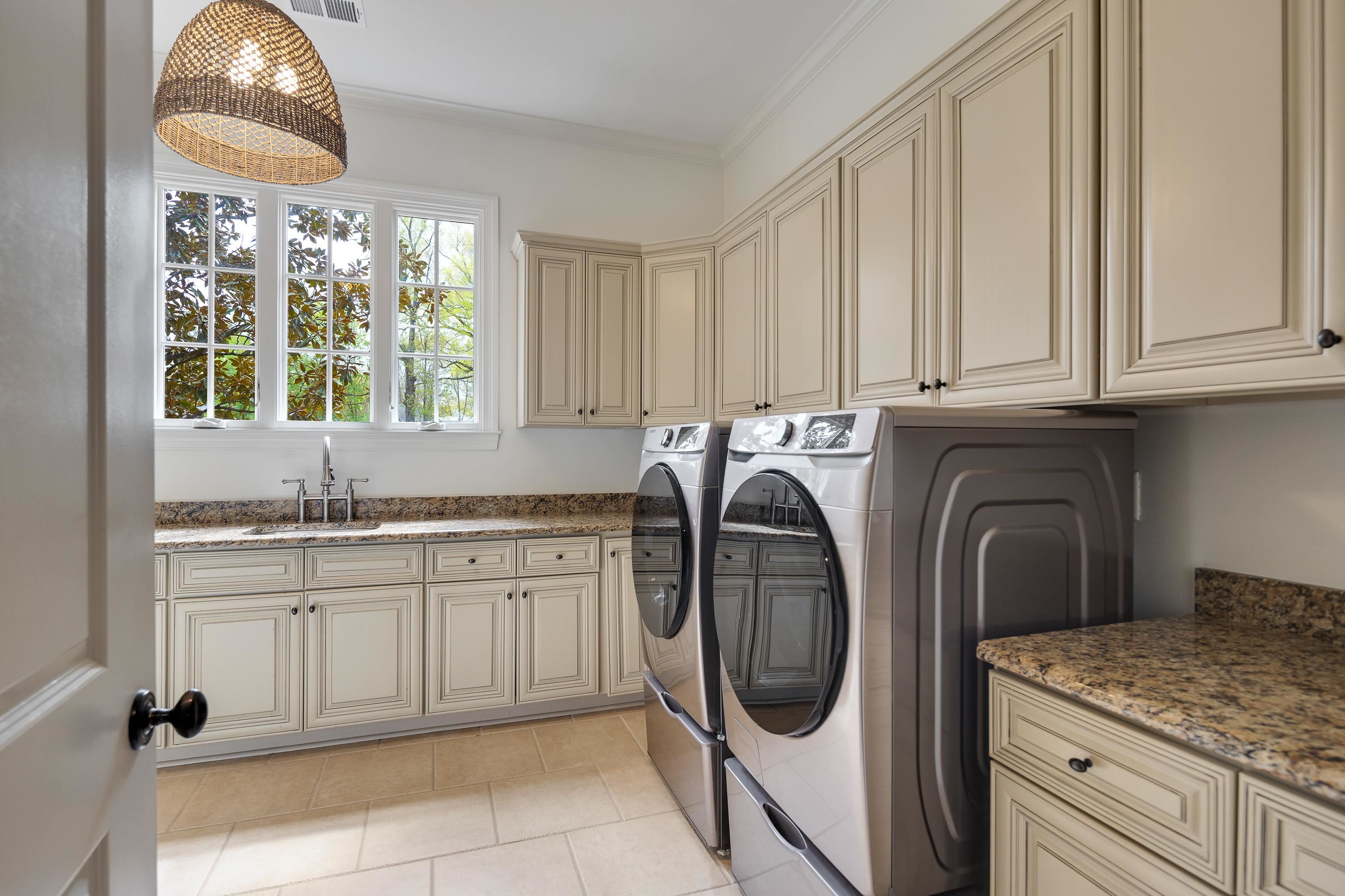 101 North Grove Park Road Memphis, TN 38117 - Photo 15 of 40 Laundry room featuring washing machine and dryer, cabinet space, light tile patterned floors, and ornamental molding