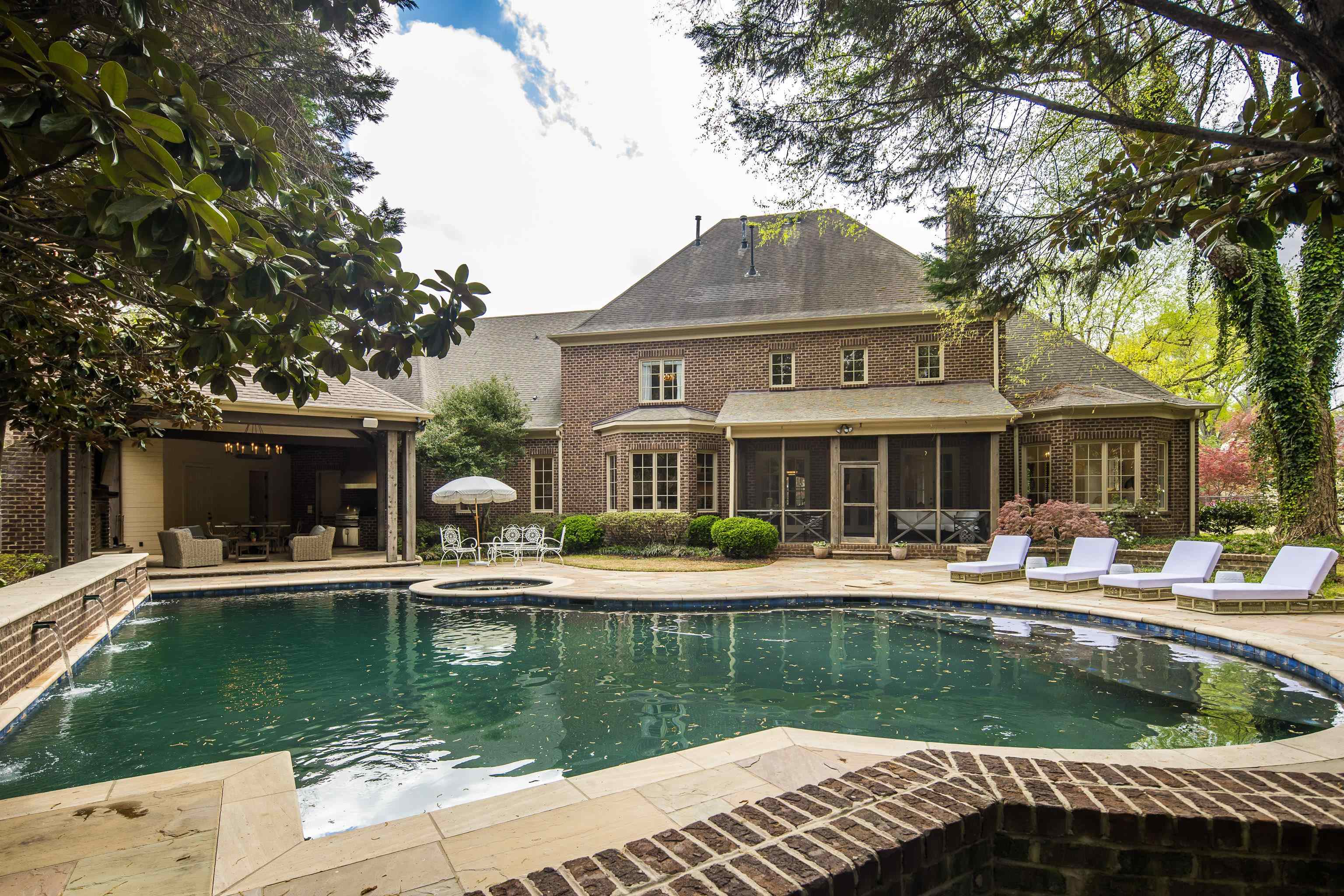 101 North Grove Park Road Memphis, TN 38117 - Photo 27 of 40 Back of property featuring an in-ground hot tub, a patio, an outdoor pool, a sunroom, and brick siding