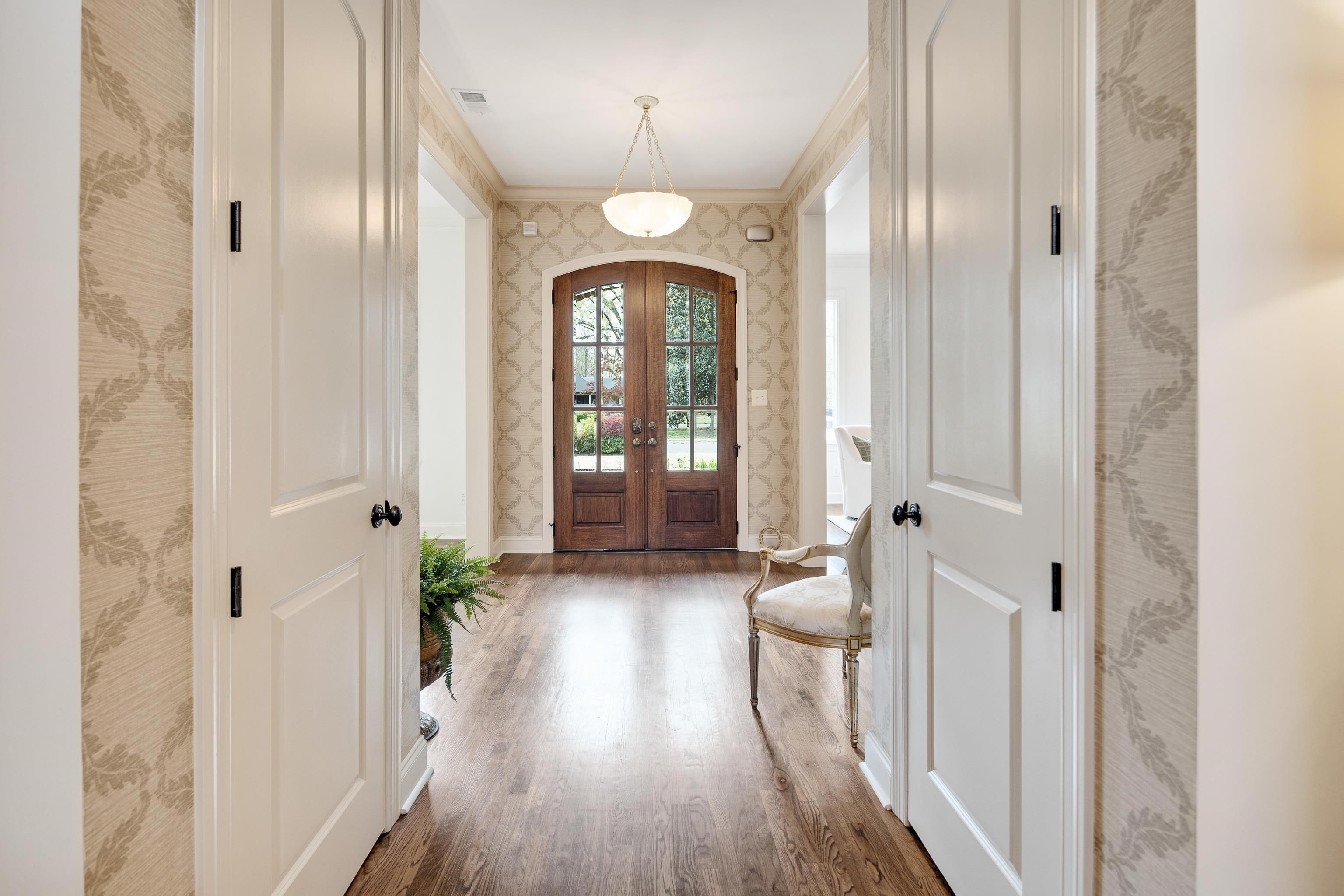 101 North Grove Park Road Memphis, TN 38117 - Photo 4 of 40 Entryway featuring wallpapered walls, crown molding, wood finished floors, french doors, and arched walkways