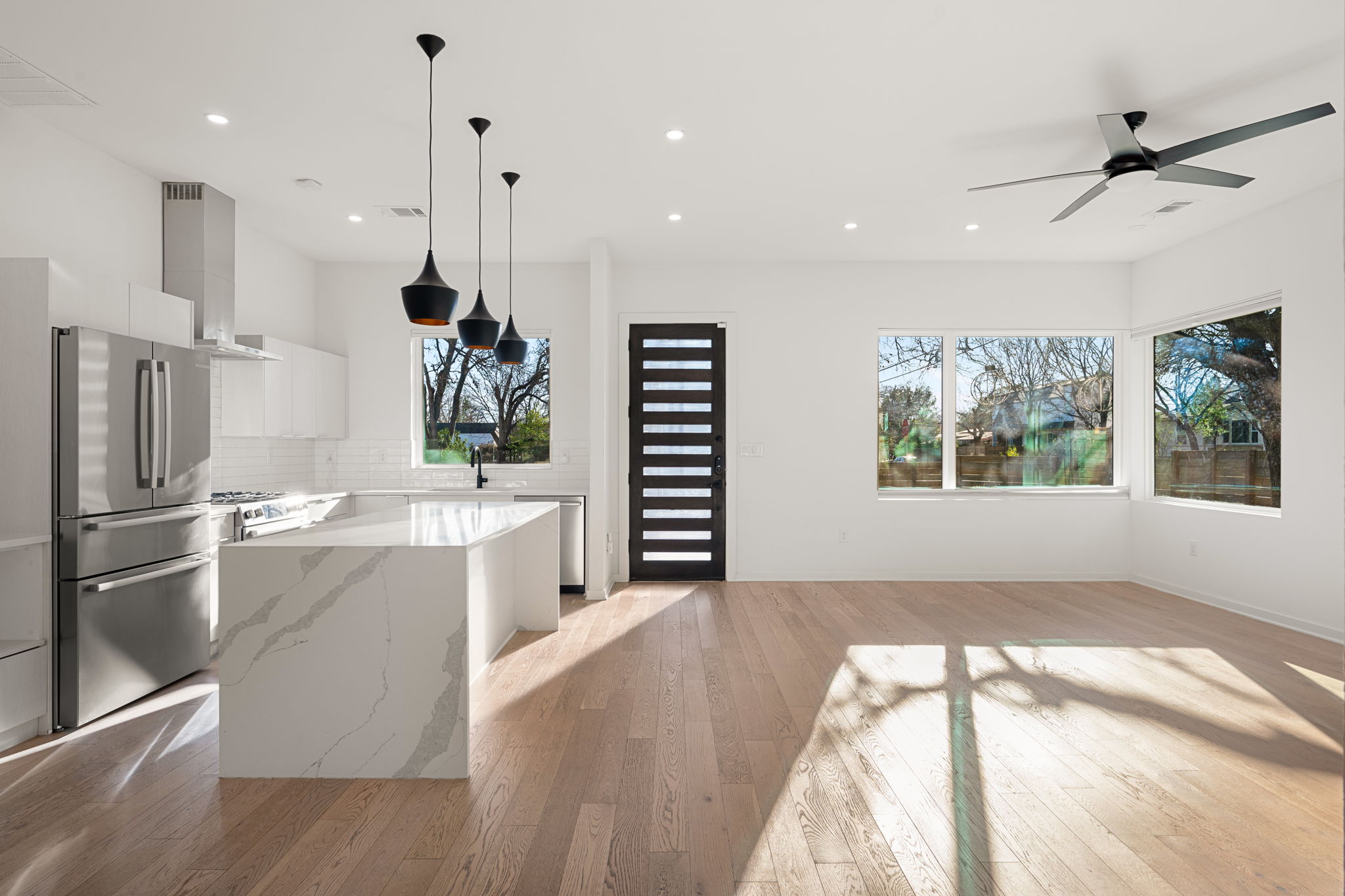 910 Nalide Street, Unit B Austin, TX 78745 - Photo 17 of 38 a kitchen with kitchen island a stove a refrigerator wooden floor and a window
