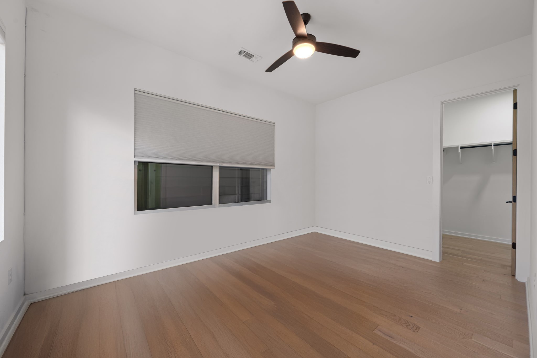 910 Nalide Street, Unit B Austin, TX 78745 - Photo 19 of 38 an empty room with wooden floor and windows