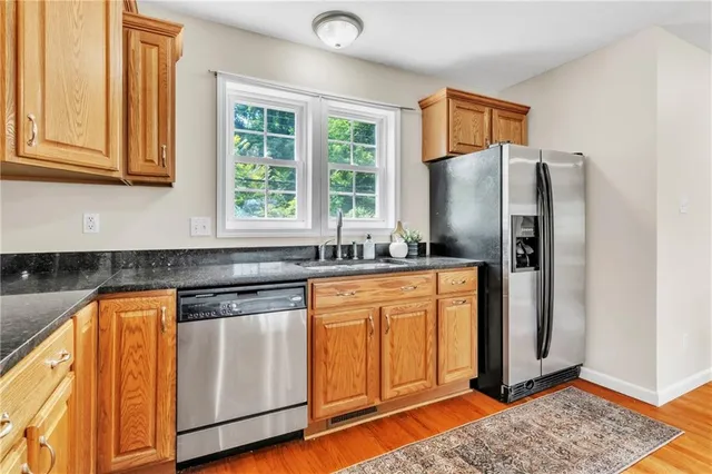 a kitchen with stainless steel appliances granite countertop a refrigerator and a sink