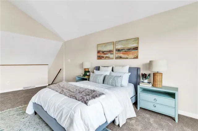 a bedroom with a bed and a painting on the wall