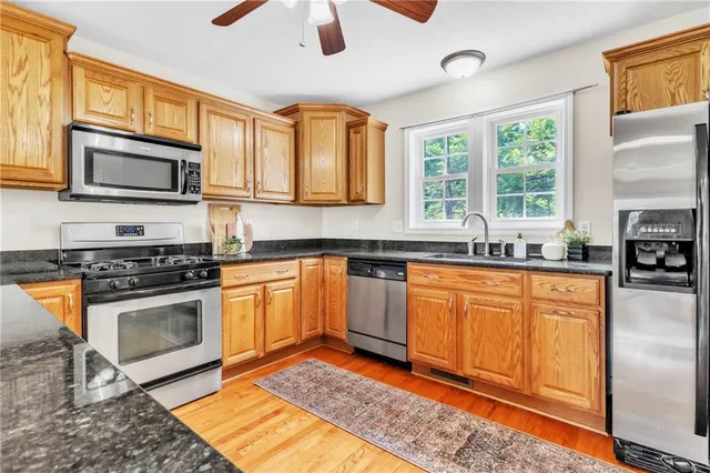 a kitchen with stainless steel appliances granite countertop a stove a sink and a microwave