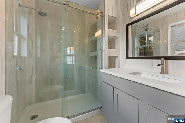 a bathroom with a shower sink and mirror