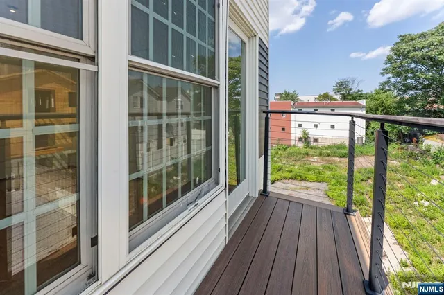a view of a balcony with floor to ceiling windows with wooden floor