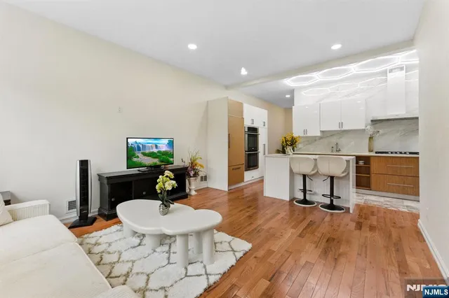 a living room with a dining table wooden floor and a dining table