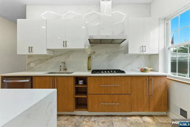 a kitchen with granite countertop a sink a stove and cabinets
