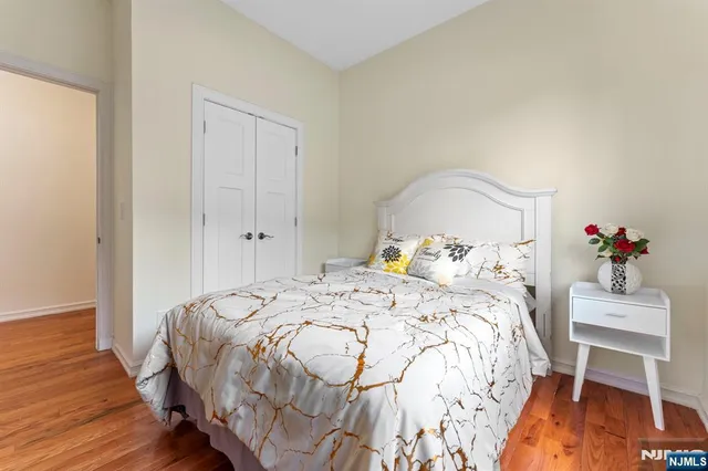 a bedroom with a bed and wooden floor