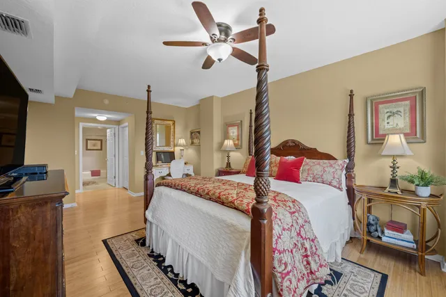 a bedroom with a bed wooden floor and a flat screen tv