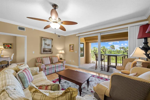 a living room with furniture a chandelier and a large window