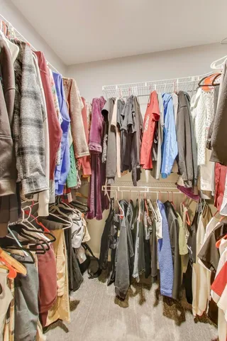 a view of walk in closet with clothes