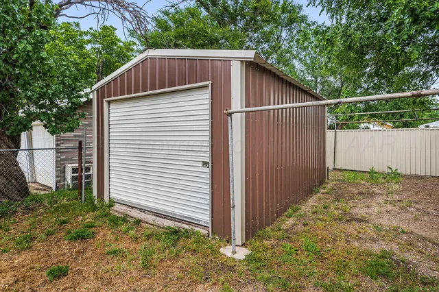 a view of a small house with wooden fence