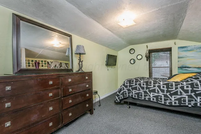 a bedroom with a bed and a dresser in it