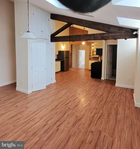 a view of empty room with wooden floor