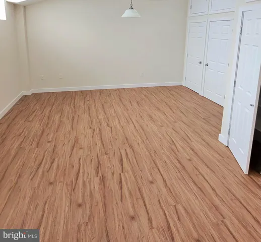 a view of a room with wooden floor and a kitchen