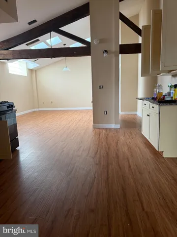 a view of a room with wooden floor and cabinets