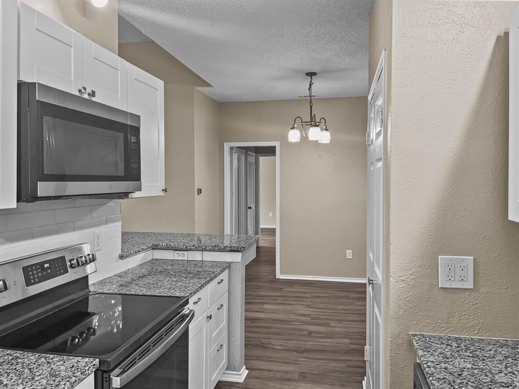 9600 Royal Lane, Unit 112 Dallas, TX 75243 - Photo 8 of 19 a kitchen with a stove and a microwave