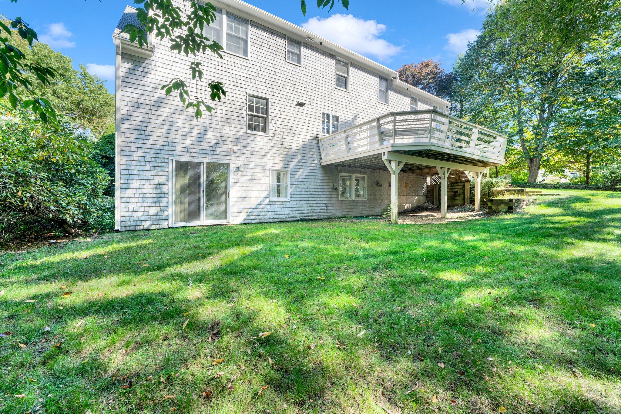7 Abbey Gate Road Cotuit, MA 02635 - Photo 37 of 41 a view of a white house with a big yard and large tree
