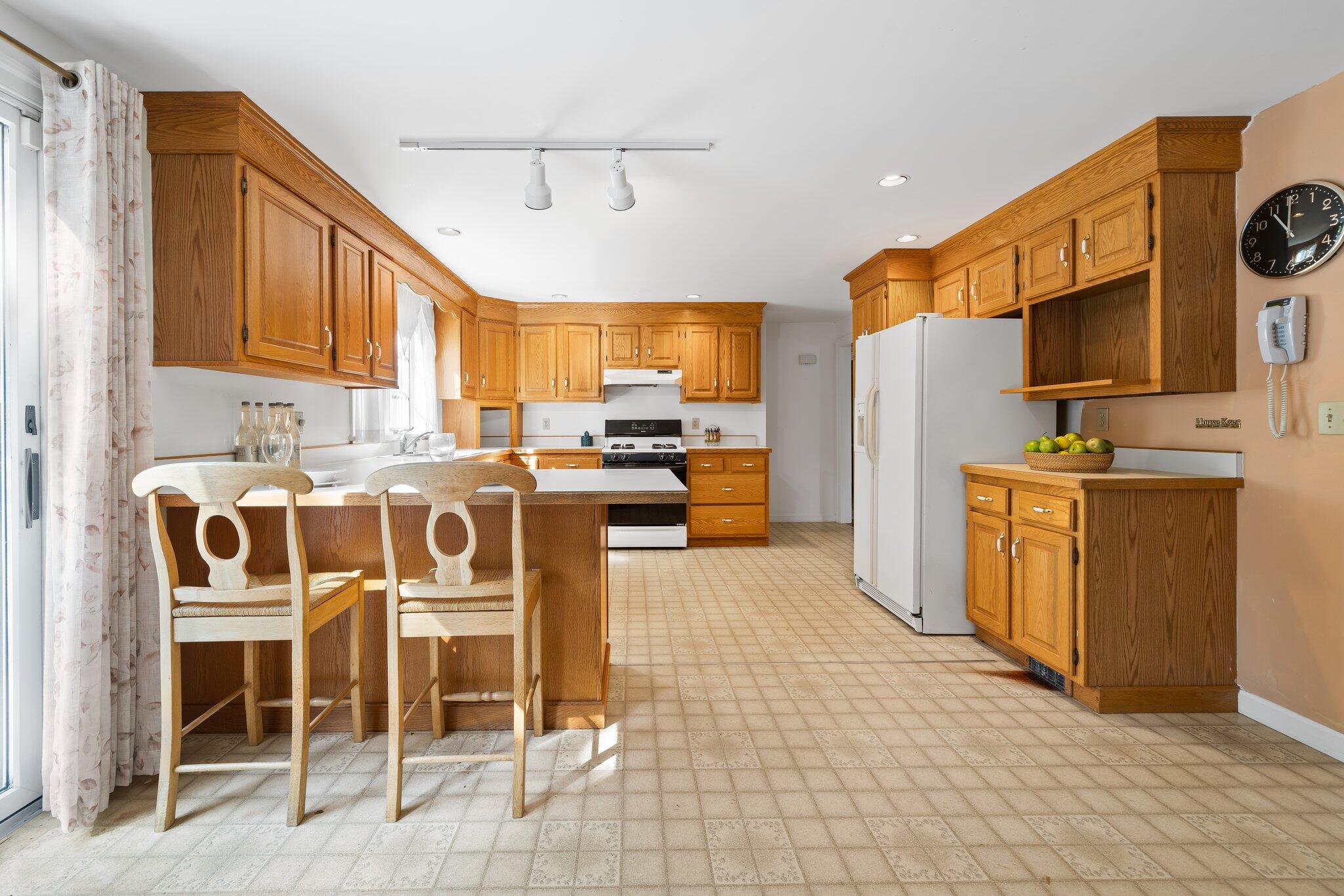 7 Abbey Gate Road Cotuit, MA 02635 - Photo 8 of 41 a open kitchen with stainless steel appliances granite countertop a stove a refrigerator a sink a dining table and chairs with wooden floor