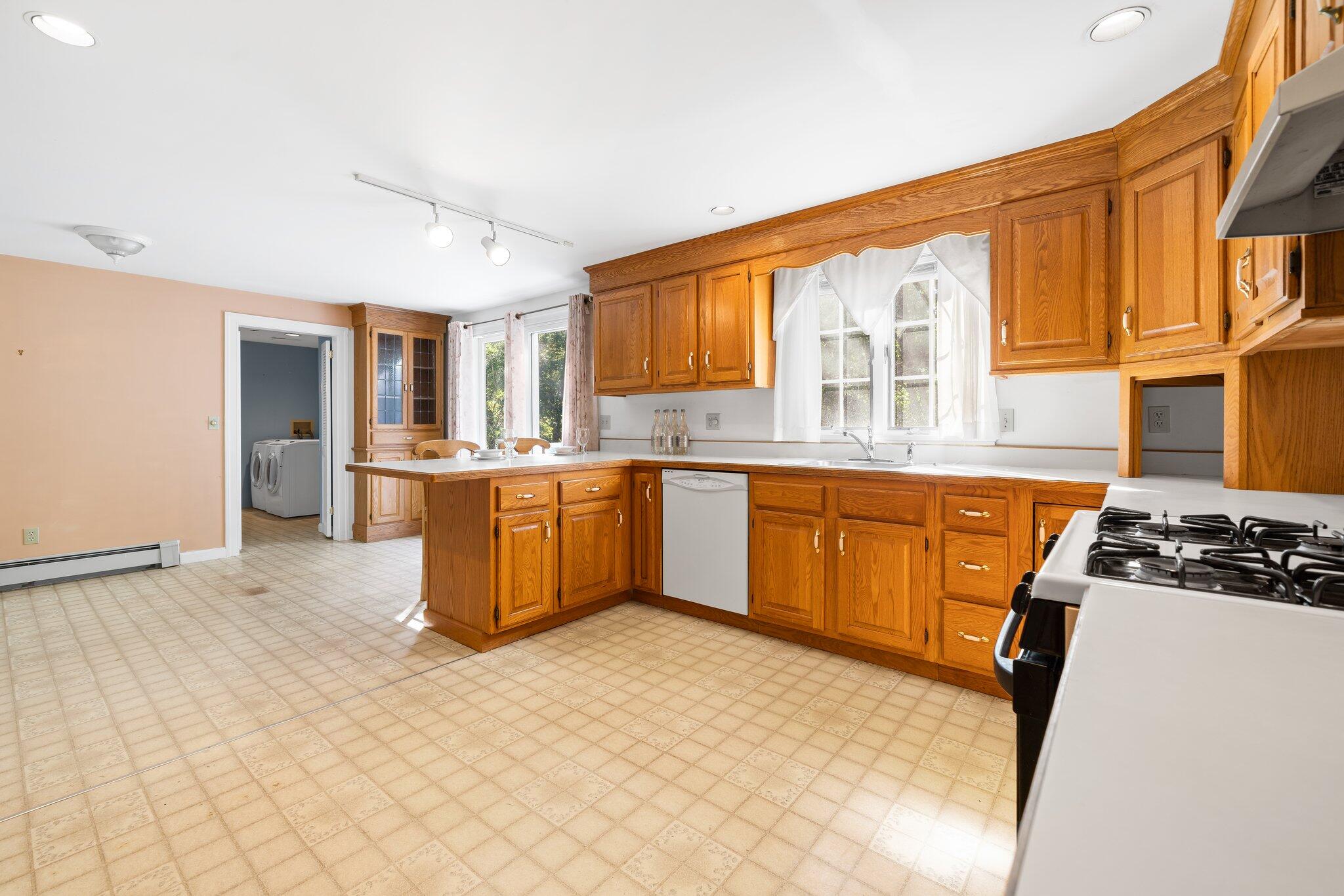7 Abbey Gate Road Cotuit, MA 02635 - Photo 10 of 41 a kitchen with stainless steel appliances granite countertop a stove top oven a sink a refrigerator and white cabinets with wooden floor