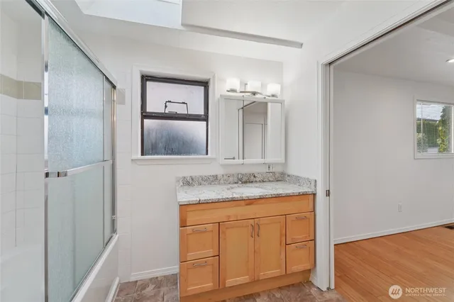 a bathroom with a granite countertop sink and a mirror