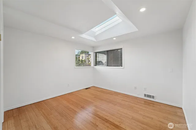 an empty room with a wooden floor and a window