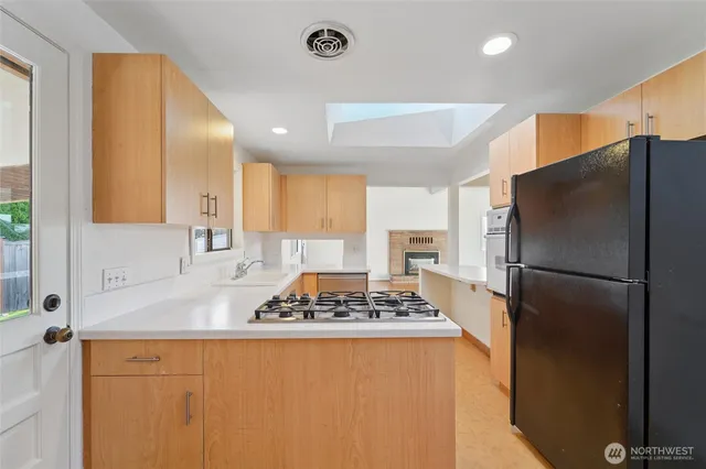 a kitchen with stainless steel appliances granite countertop a refrigerator and a sink