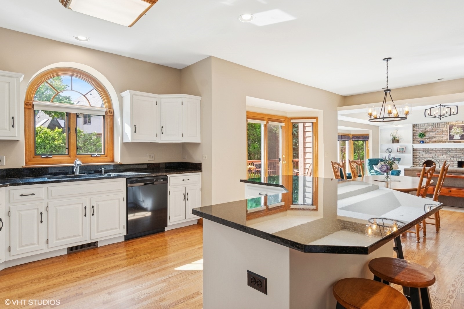 727 Mesa Drive Naperville, IL 60565 - Photo 6 of 31 a kitchen with granite countertop a stove a sink a dining table and chairs with wooden floor