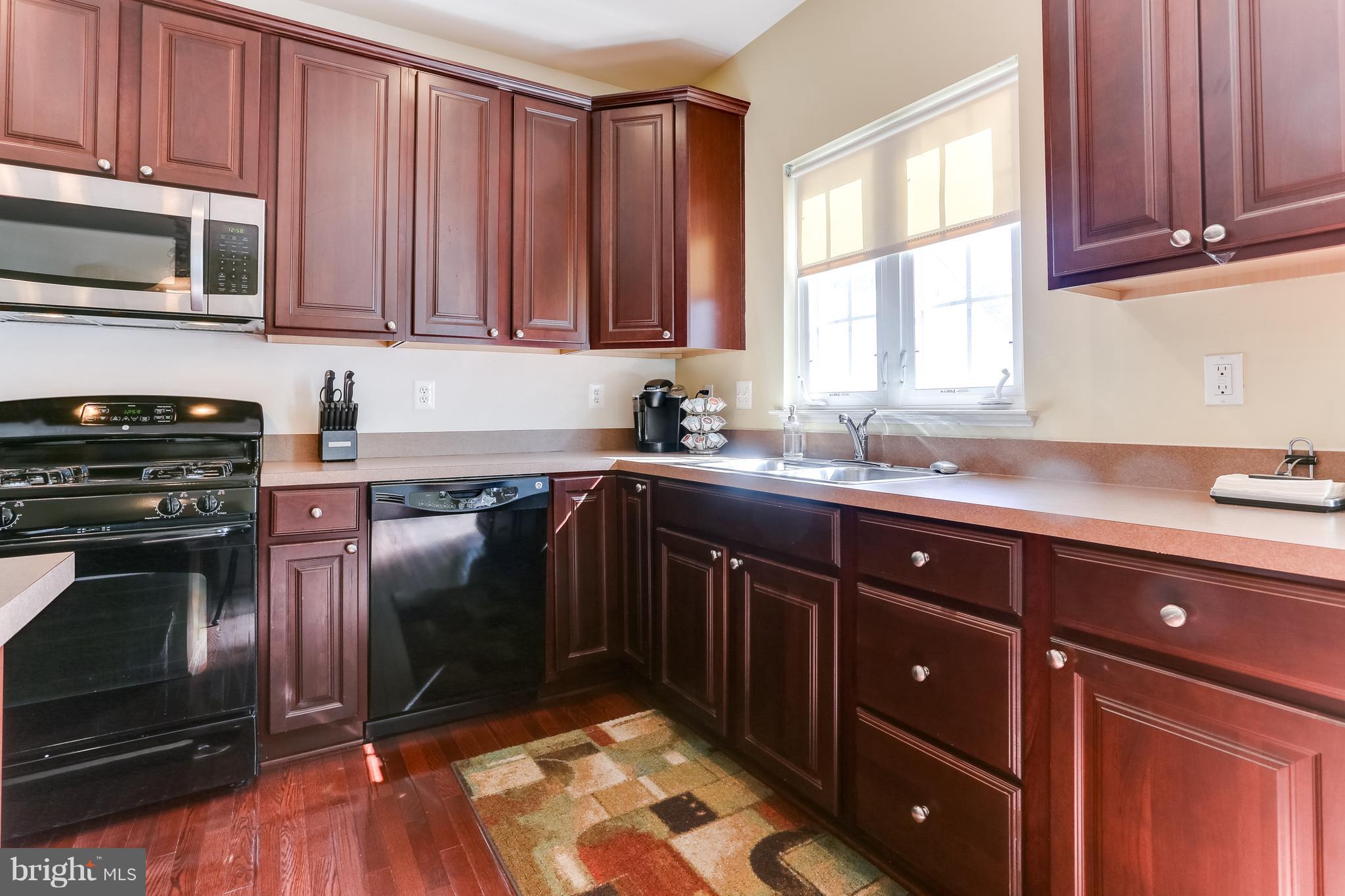 6912 Red Clay Forge, Unit 2 Elkridge, MD 21075 - Photo 8 of 30 a kitchen with a sink stove and microwave