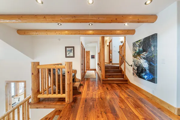 a view of a living room with wooden floor and stairs