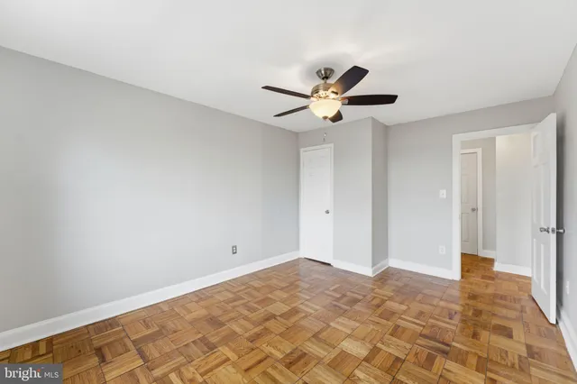 a view of a big room with wooden floor and a chandelier fan