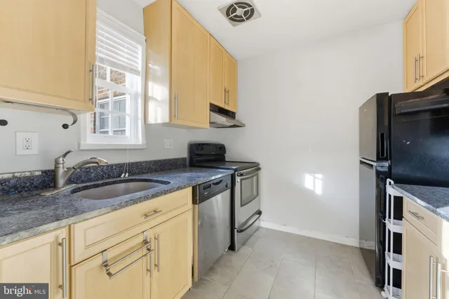 a kitchen with granite countertop a sink stainless steel appliances and cabinets