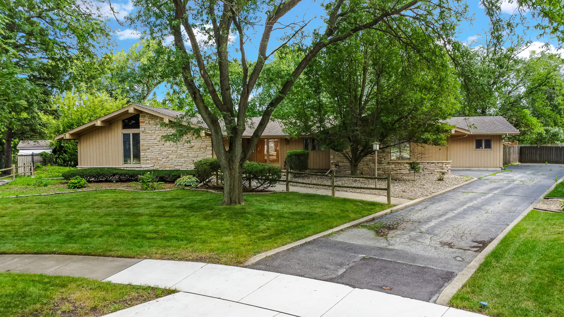 a front view of a house with a yard and trees