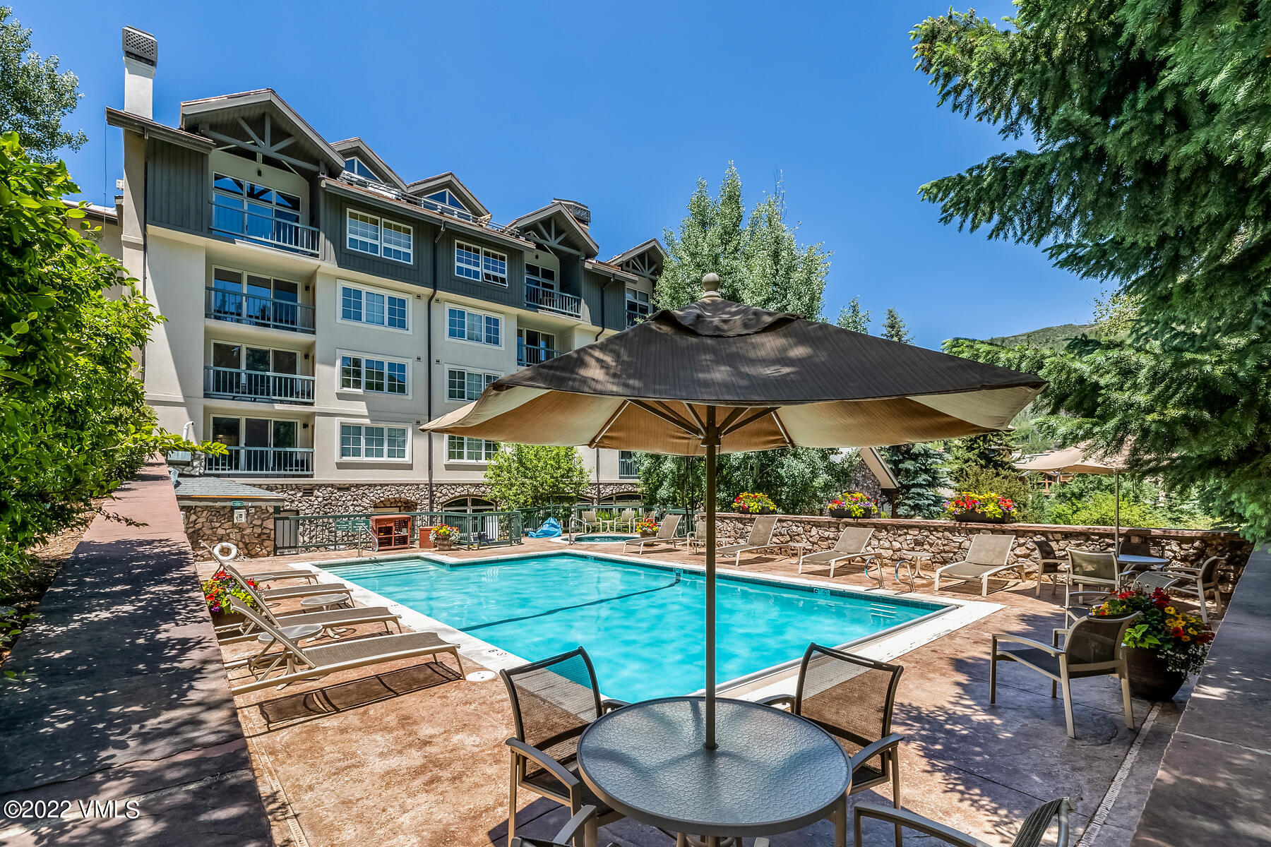 1120 Village Road, Unit 402 Beaver Creek, CO 81620 - Photo 35 of 46 a swimming pool with outdoor seating and yard