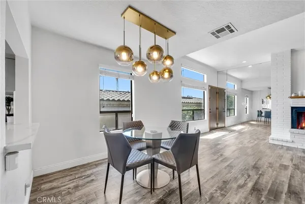 a dining room with wooden floor a chandelier a wooden table and chairs
