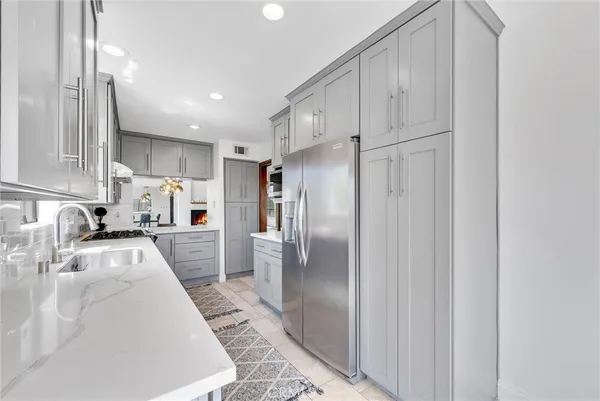 a kitchen with white cabinets sink and stainless steel appliances