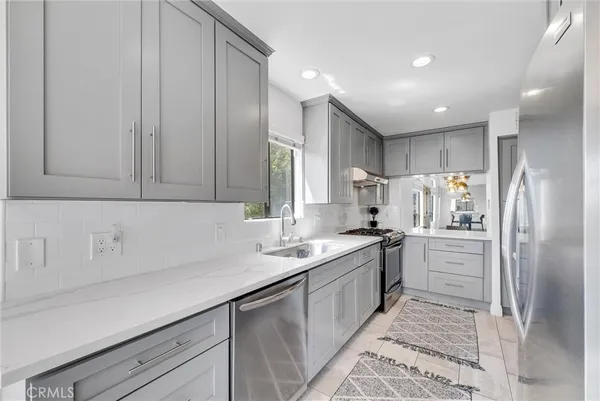 a kitchen with white cabinets and appliances