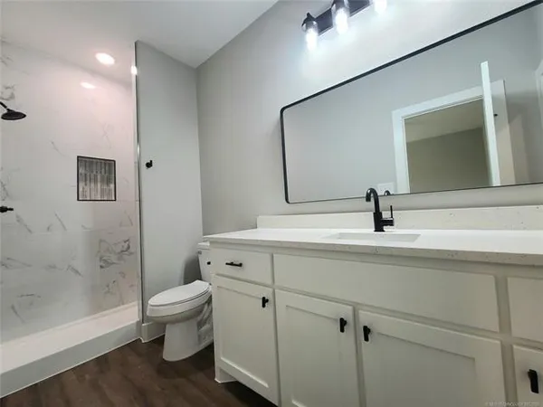 a bathroom with a toilet a sink and mirror