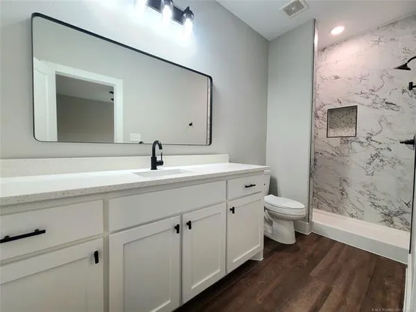 a bathroom with a sink a toilet and shower