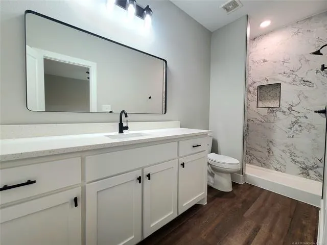 a bathroom with a sink a toilet and shower