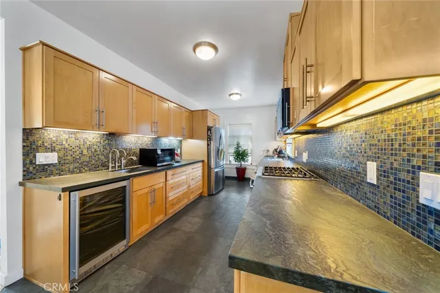 a kitchen with stainless steel appliances granite countertop a stove a sink and a microwave