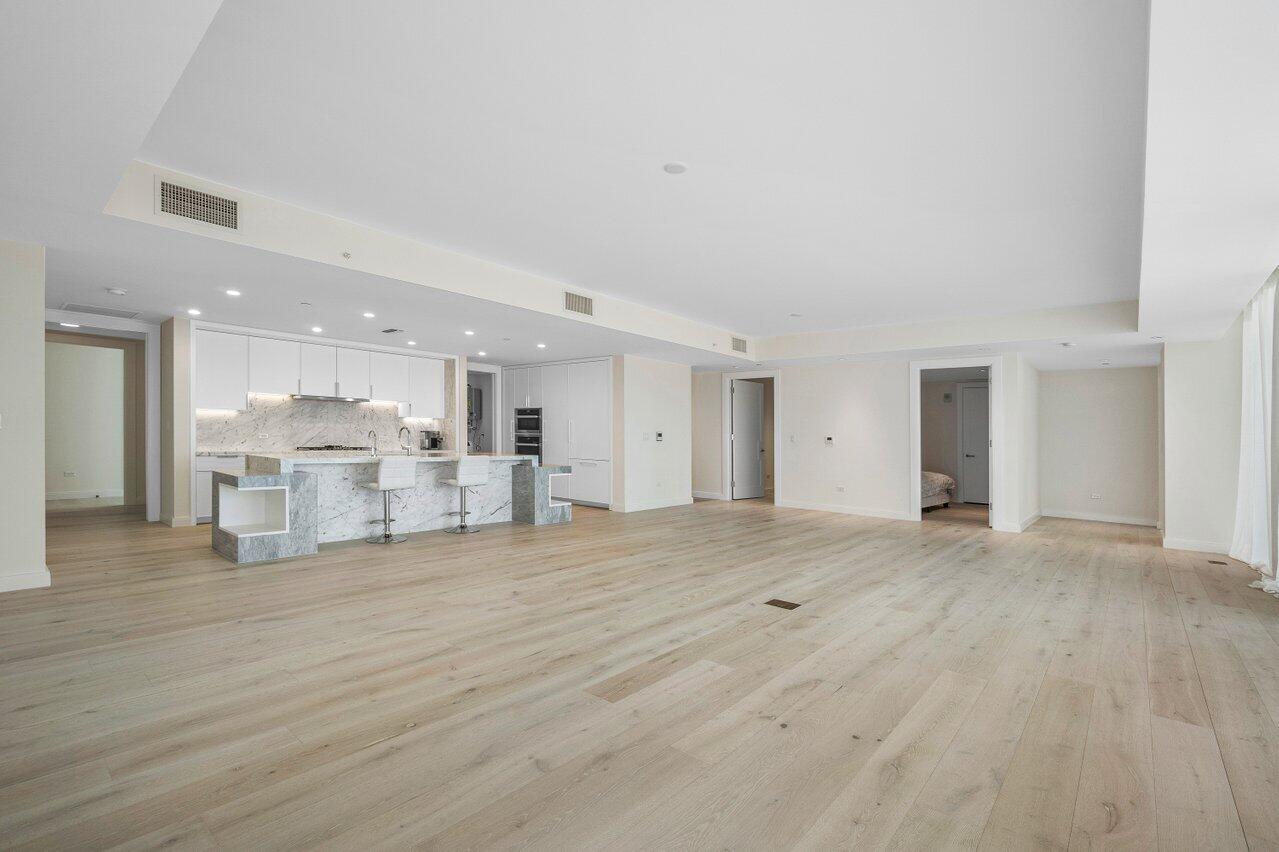 3550 South Ocean Boulevard, Unit 2D South Palm Beach, FL 33480 - Photo 11 of 55 a view of a kitchen with kitchen island a sink wooden floor and a refrigerator