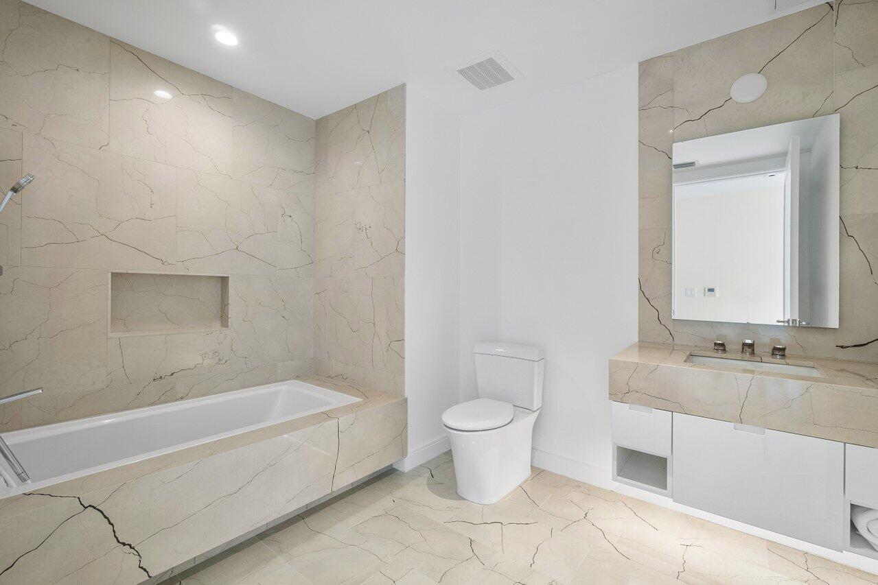 3550 South Ocean Boulevard, Unit 2D South Palm Beach, FL 33480 - Photo 22 of 55 a bathroom with a granite countertop sink a toilet and bathtub