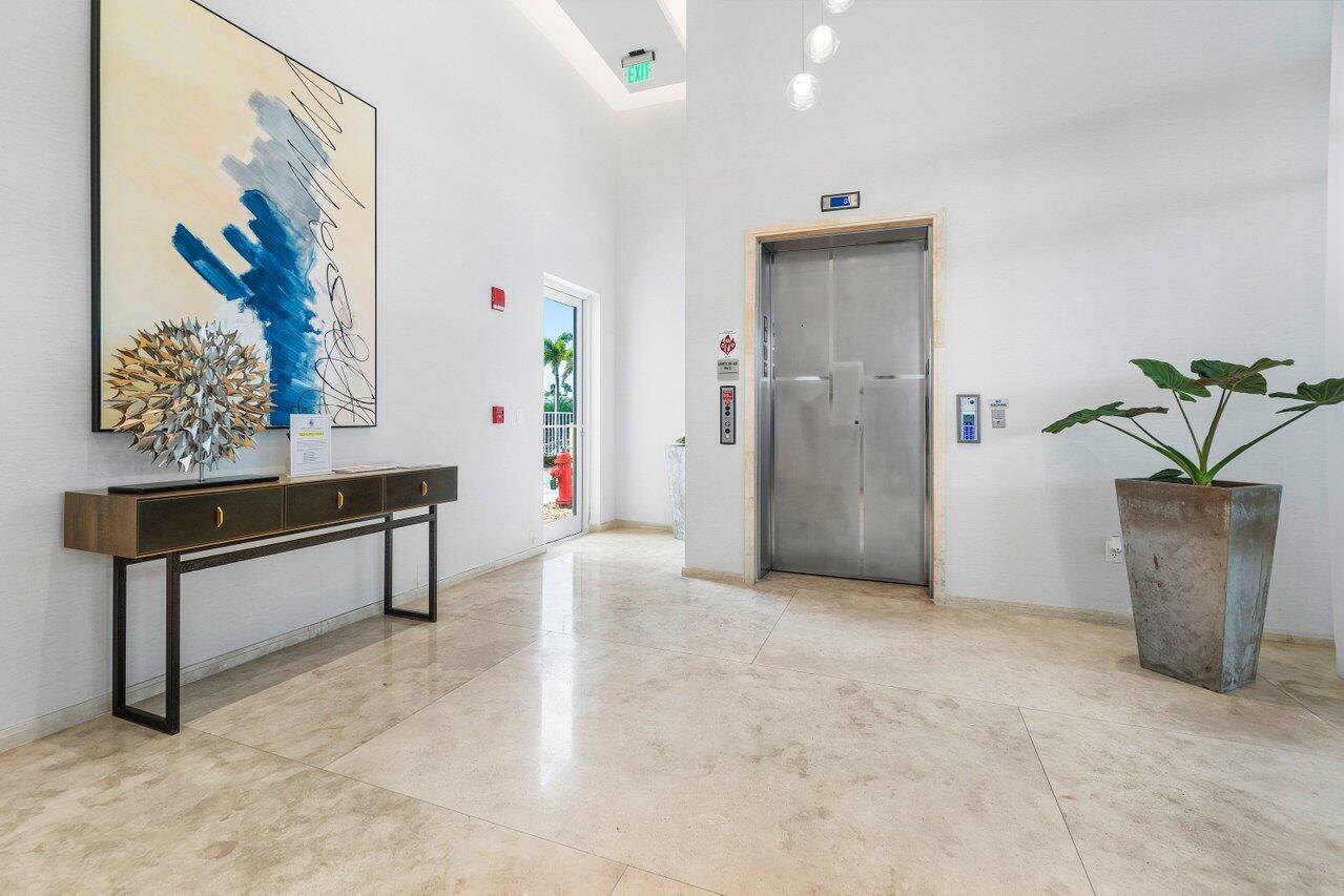 3550 South Ocean Boulevard, Unit 2D South Palm Beach, FL 33480 - Photo 34 of 55 a view of a hallway with paintings on the wall and a potted plant