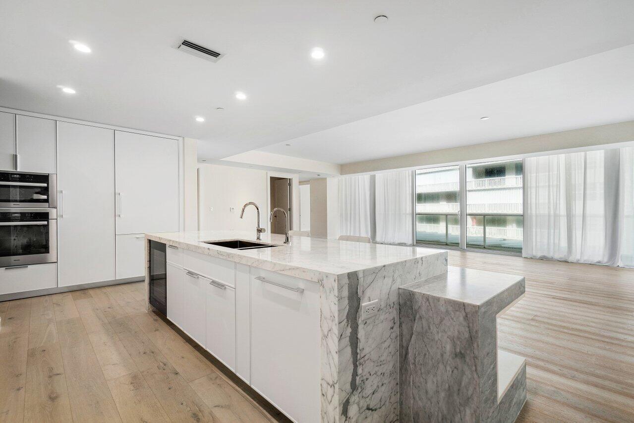 3550 South Ocean Boulevard, Unit 2D South Palm Beach, FL 33480 - Photo 7 of 55 a large kitchen with stainless steel appliances granite countertop a lot of cabinets and wooden floor