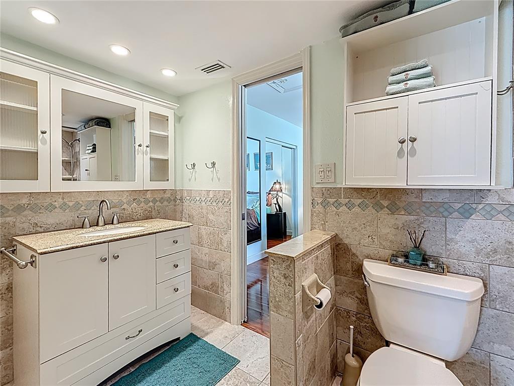 230 Medallion Boulevard, Unit G Madeira Beach, FL 33708 - Photo 29 of 38 a bathroom with a toilet sink and mirror