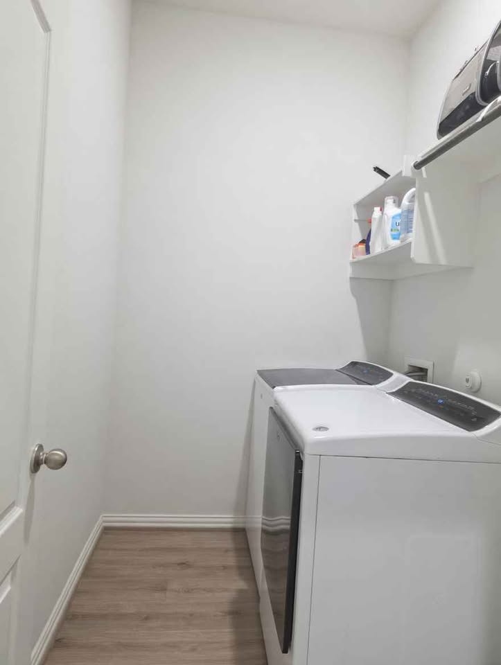 4105 Gildas Path Pflugerville, TX 78660 - Photo 15 of 15 Functional laundry space featuring durable wood flooring and convenient overhead shelving.