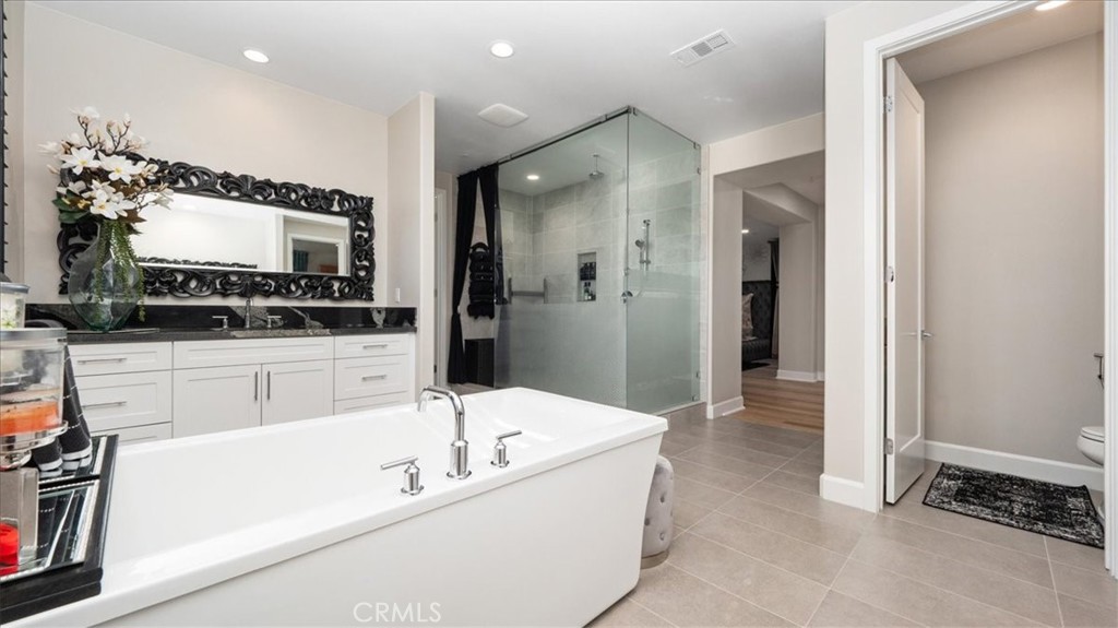 8798 JUSTIFY Drive Rancho Cucamonga, CA 91701 - Photo 16 of 26 a bathroom with a tub a sink and a large mirror